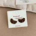 Crescent-shaped brown leopard print flocked stud earrings on a white display card - Cashew Leopard Flocked