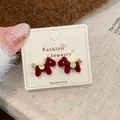 Red flocked pony stud earrings with golden accents on a minimalist jewelry card - Red Horse Earrings (MMW37)