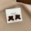Cute dark brown flocked bear stud earrings for women shown on jewelry display card - Lying Bear / Coffee