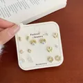 Elegant 9-pair gold earring set with pearls and crystals on a display card - Lazy Sleeping Cat