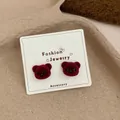 Cute burgundy flocked bear head stud earrings displayed on a fashion jewelry card - Bear Head / Red