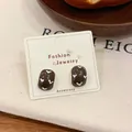 Chocolate brown vintage heart cube earrings on cream card with warm lifestyle decor - Arch Stud Earrings / Brown