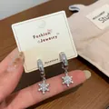 Elegant silver snowflake hoop earrings with sparkling cubic zirconia on a jewelry card - Snowflake Glitter C-Hoop Earring Set