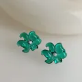 Primer plano de pendientes de flores verde esmeralda en resina con centros de cristal brillo - Verde