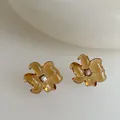 Primer plano de pendientes de flor de resina ámbar con cristal sobre fondo beige claro - Marrón