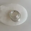Macro view of a multi-layer silver coil ring displayed on a white marble stone plate - Multi-layer Wrap Ring