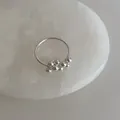 Macro detail of multi-layer silver coil ring with small clusters of polished silver beads - Metal Ball Ring