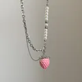 Vista macro detallada de cadena asimétrica con colgante de fresa 3D rosa y perlas blancas - Estilo 5 Collar de Empalme de Perlas y Cadena Gruesa