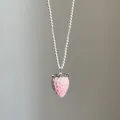 Detail eines rosa Erdbeeranhängers mit Textur an einer weißen Perlenkette für Damen - Stil 5 Halskette