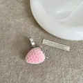 Nahaufnahme eines rosa beflockten Erdbeeranhängers mit silbernem Blatt auf weichem Stoff - Stil 8 Ring