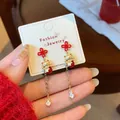 Red Chinese knot and lucky cat earrings with golden chains and crystals on display - Chinese Knot Maneki Neko Drop Style (ZCM6)