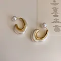 Macro view of French vintage geometric metal and resin earrings with a pearlescent finish - Pearl Irregular Style