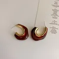 Detail view of retro geometric C-shape earrings with amber resin and gold metal finish - Brown Irregular Style