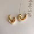Close-up of C-shaped gold metal and cream marble resin earrings with S925 silver pins - Beige Irregular Style