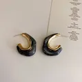 Detail view of French retro gold metal and black marbled resin geometric hoop earrings. - Gray Irregular Style