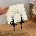 Asymmetric earrings with light blue star and black flocked cat pendant on white card - Blue Star Black Cat Earrings (MMW52)