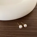 Primo piano dettagliato di orecchini di perle da 8mm con perni dorati su legno e ceramica - Stile Perla di Conchiglia (Y-0308) / 8mm