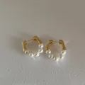 Close-up of gold metal hoop earrings with five white pearls on light grey background - Real Gold Plated Metal With Imitation Pearl and 925 Sterling Silver Earring Post