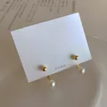 Detailed view of 925 silver needle pearl earrings with gold spheres on display card - 925 Silver Post Gold Plated / Pearl Earring Style