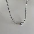 Detailed macro view of the twisted silver metal chain and round grey pearl pendant - Dark Grey Pearl / Silver Necklace (Gold Plated)
