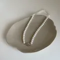 Détail du collier de perles de verre avec fermoir haricot argenté sur plateau céramique - Taille 6 Plaqué Or