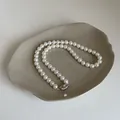 Détail de perles de verre blanches élégantes avec fermoir en métal sur plateau - Taille 7 Plaqué Or
