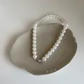 Détail d'un collier de perles en verre élégant avec fermoir argenté sur plateau - Taille 10 Plaqué Or