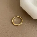 Detailed close-up of a gold adjustable ring with polished finish and circular groove patterns - Gold / Real Gold Plated