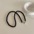 Close-up of black beaded necklace with a polished silver heart-shaped toggle clasp - Magnetic Heart Style