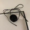 Close-up of handmade black satin rose choker necklace with thin lace-up ribbon ties - Medium Black Flower Necklace