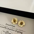 Detail of vintage gold hammer texture earrings featuring oval tiger eye stone inlays - Tiger's Eye (Gold) / Gold