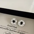 Detailed close-up of silver irregular hammered earrings with black oval natural stone - Agate (Silver) / Silver