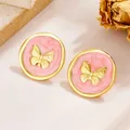 Makroaufnahme von Vintage-Schmetterlingsohrsteckern mit rosa Marmoremaille in Gold - Rosa