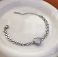 Silbernes Edelstahl-Armband mit Herzanhänger und Perlenrand für Damen im Trend - Armband / Stahlfarben