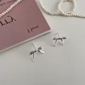 Detailed view of silver bow-shaped metal stud earrings on a minimalist decorative background - 925 Silver Post Gold Plated / One Pair Bowknot Stud Earrings