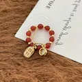 Macro view of Chinese style red beaded ring with golden Good Luck charm and zircon - Lucky Pendant Ring Gold Plated