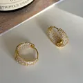 Close-up of gold wide hoop earrings with micro-pave white zircon stones for women - Gold