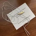 Detailed close-up of a two-tone silver snake chain with a golden streamlined metal pendant - Gold Necklace (Gold Plated)