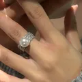 Detailopname van een brede zilveren ring met een grote parel en pavé gezette zirkoon - Witte Parel Ring (D3-41) / Wit