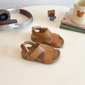 Brown children's leather sandals with cutout design and velcro strap on white desk - Size 21 (13.5cm) / Tan