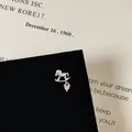 Macro detail of silver rocking horse earring with pink heart zircon on display card - Trojan Horse Style (5506020064610)