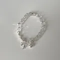 Detail eines Perlenarmbands mit klaren facettierten Kristallen und Schleifenanhänger - Schleifen-Ball-Anhänger-Stil (Stil 11)