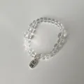 Nahaufnahme des transparenten Perlenarmbands mit silbernem Glücksbringer-Anhänger - Glücks-Tag Perlen-Stil (Stil 6)