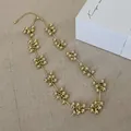 Detailaufnahme der goldenen Perlenkette mit Kugelclustern auf Leinenstoff - Goldene Halskette Echtgold Vergoldet / Gold