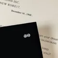 Macro view of blue zircon bow screw back earrings with silver plating on black velvet - Bow Design (Style 14 Helix Stud)
