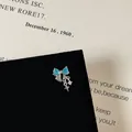 Close-up of blue zircon bow earring with star pendant and silver chain detail - Blue Gemstone Star Pendant Style (Model 15 Cartilage Stud)