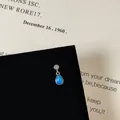 Detailed macro view of silver screw back earring with blue opal and sparkling zircon stud - Round Teardrop Blue Opal Style (Style 19 Helix Stud)