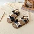 Elegante schwarz-weiße Mädchensandalen mit großer Schleife und verstellbarem Riemchen - EU 26 / Schwarz