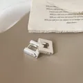 Detailweergave van vierkante geborstelde zilveren oorbellen met gegraveerd lachend gezicht - Zilver