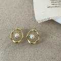 Detailopname van onregelmatige gouden oorsteker met een gladde witte ronde parel - Goud
